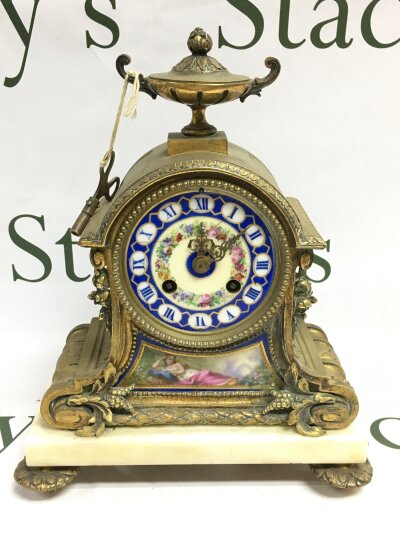 A late 19th century French mantle clock with porcelain panels and enamel decoration.