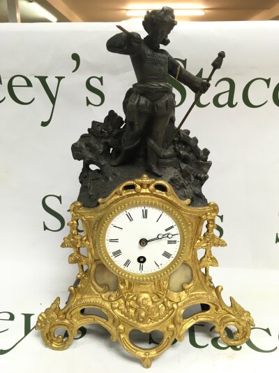 A French figural mantle clock with a guilt metal base.