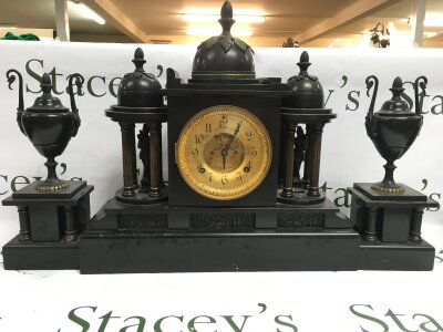 A 19th century Victorian architectural black marble mantle clock with garnitures.