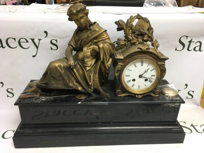 A 19th century French figural mantle clock with a black marble base.