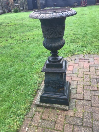 A pair of cast iron Neo-Classical garden urns with raised relief folate scroll decoration early 20th century Height 120cm