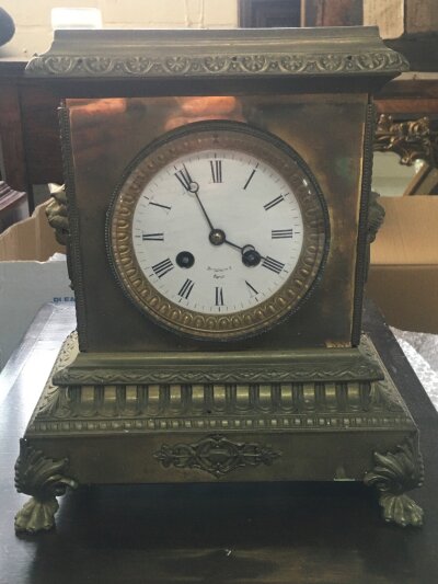 A brass cased Mantle clock featuring lion head embellishments and ornate decorative casting, Brt Voltaire 7 Paris. 28cm tall 24cm wide