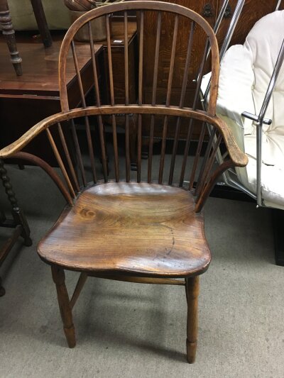A 19th century elm open arm chair the solid seat on turned legs .