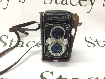 A vintage Yashica 635 twin lens reflex camera in leather case, part of the case is missing.