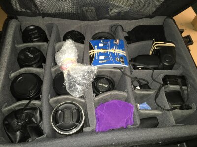 A collection of camera lenses including Tamron, Nikon, Sigma etc all stored in a Vanguard case