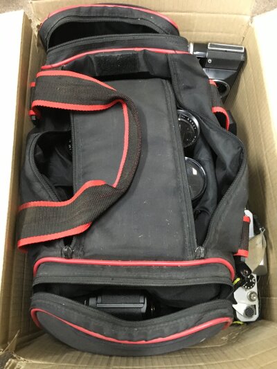 A box of camera equipment including a Zenit EM Olympic SLR camera, Yashica BX20 SLR camera , Mamiya P3 SLR camera , Zenit 12 SLR, various lens