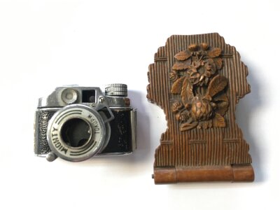 A small carved wood watch case and a miniature camera
