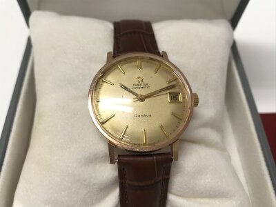 A vintage Omega automatic Geneve with gold tone dial and brown leather strap.