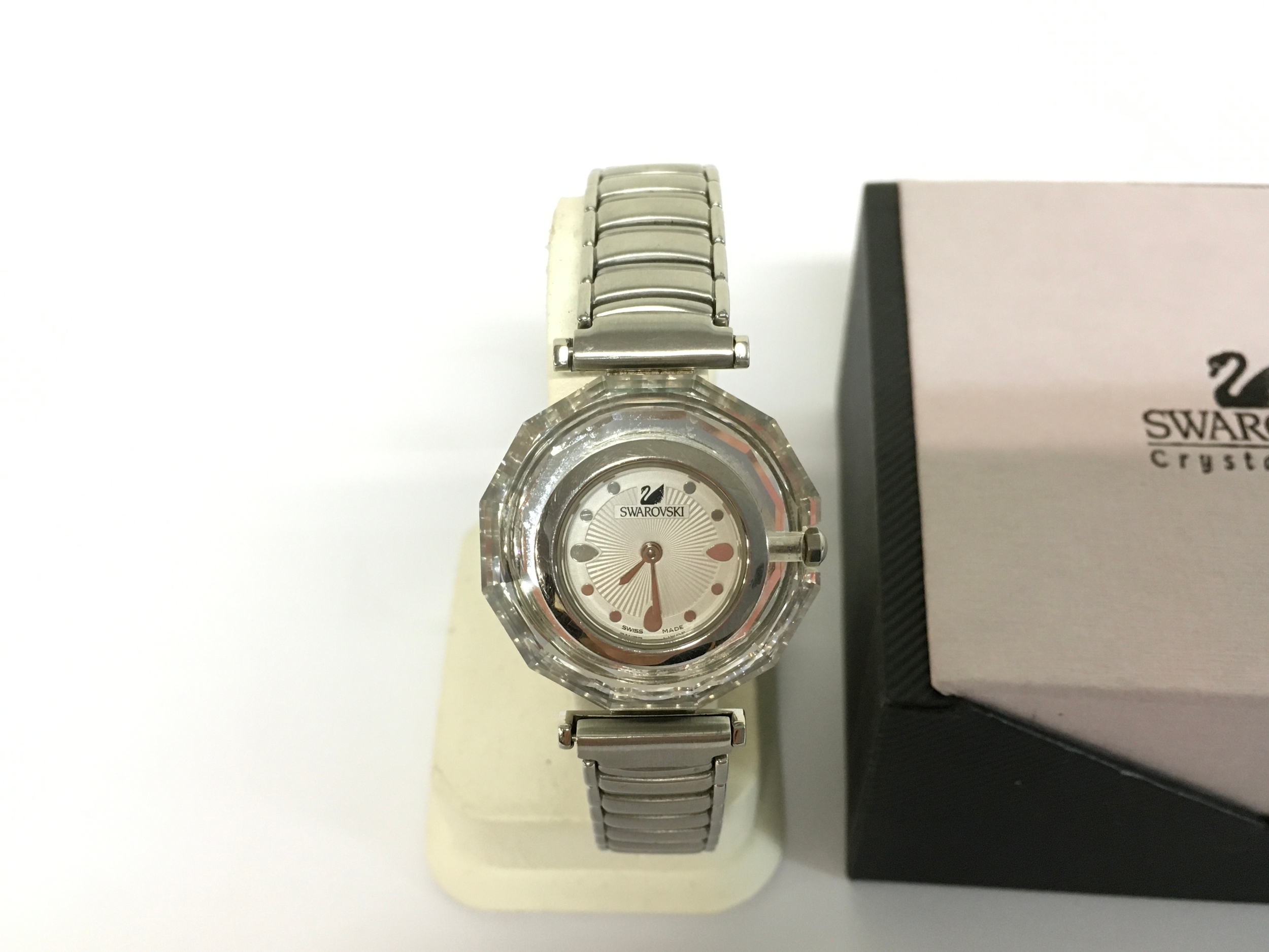 Swarovski Crystal Time watch features a distinctive clear crystal bezel and a silver-tone metal band. Comes with its box.