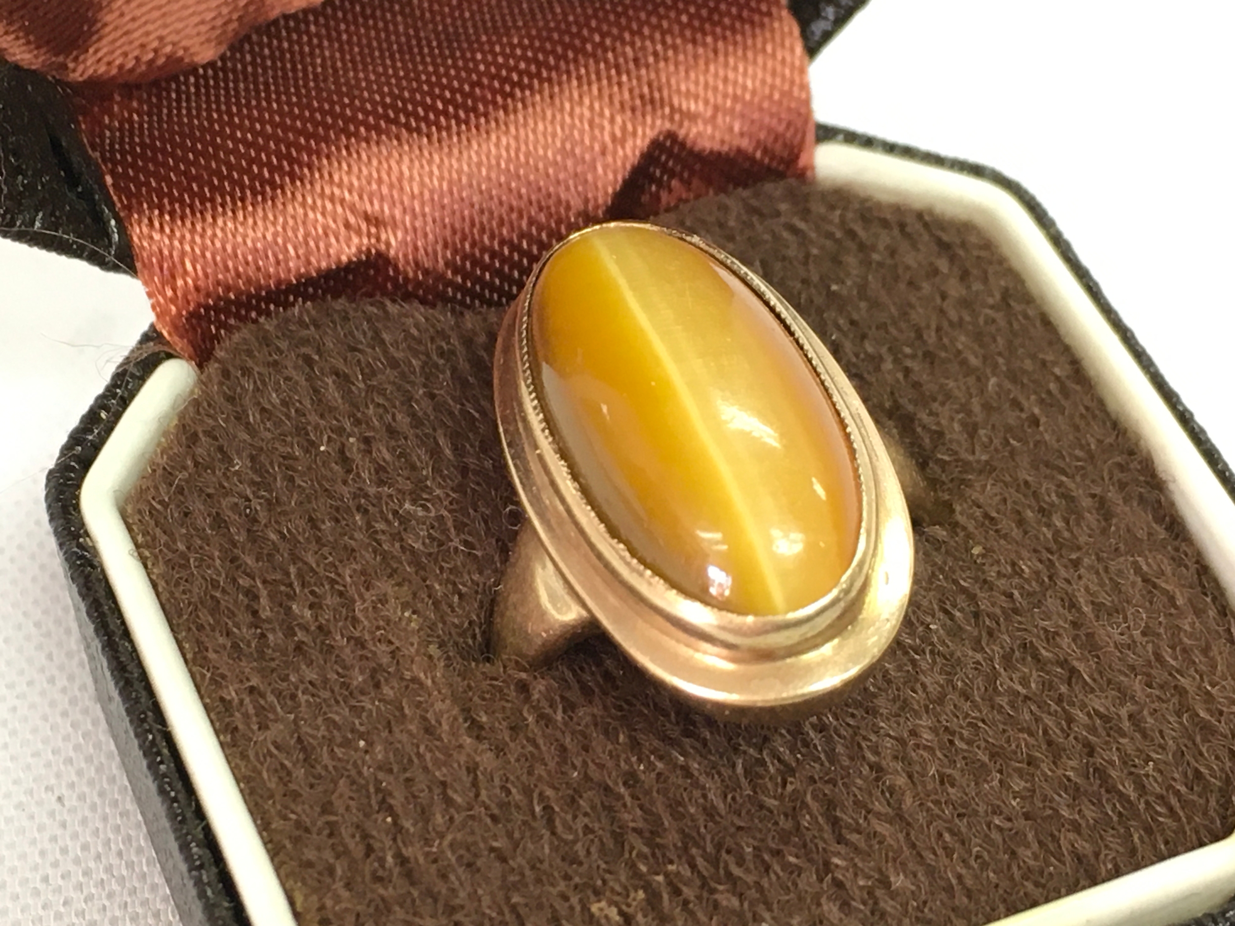 A 9ct gold ring set with tigers eye stone, size I . 3.9g