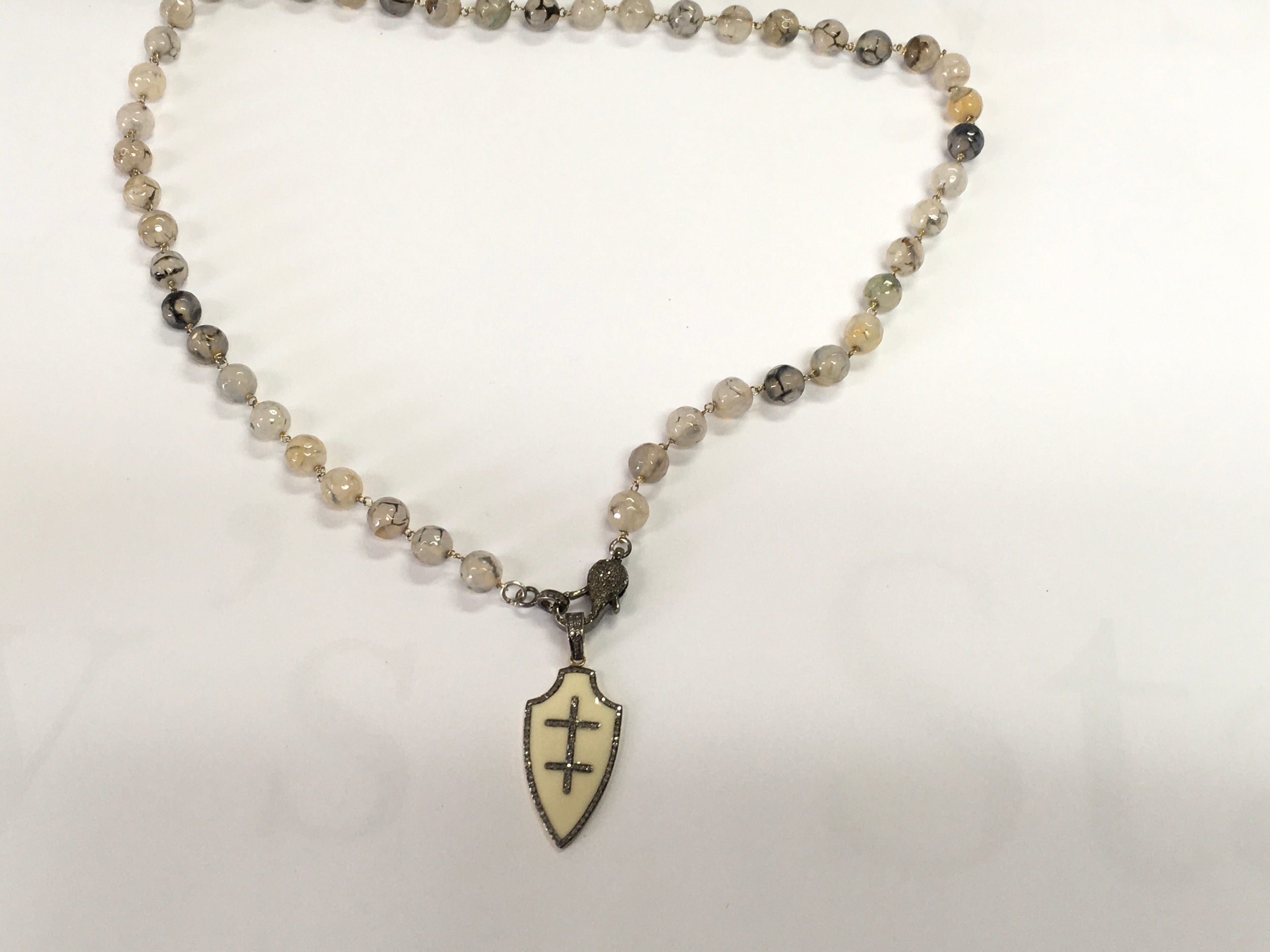 Unusual heraldic style string of faceted agate beads with emerald and diamond shield armoury and piscine diamond clasp.