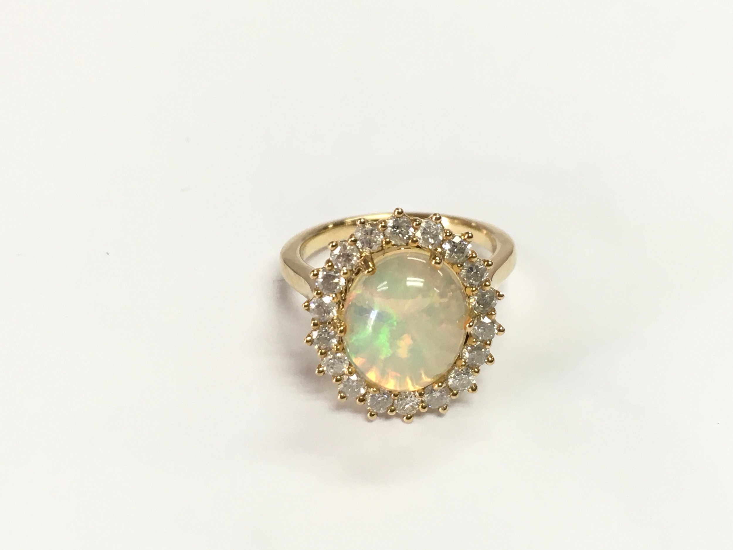 9ct gold cluster ring set with cabochon opal surrounded by a halo of diamonds. Opal 1.93ct and diamonds 0.80ct size N 1/2