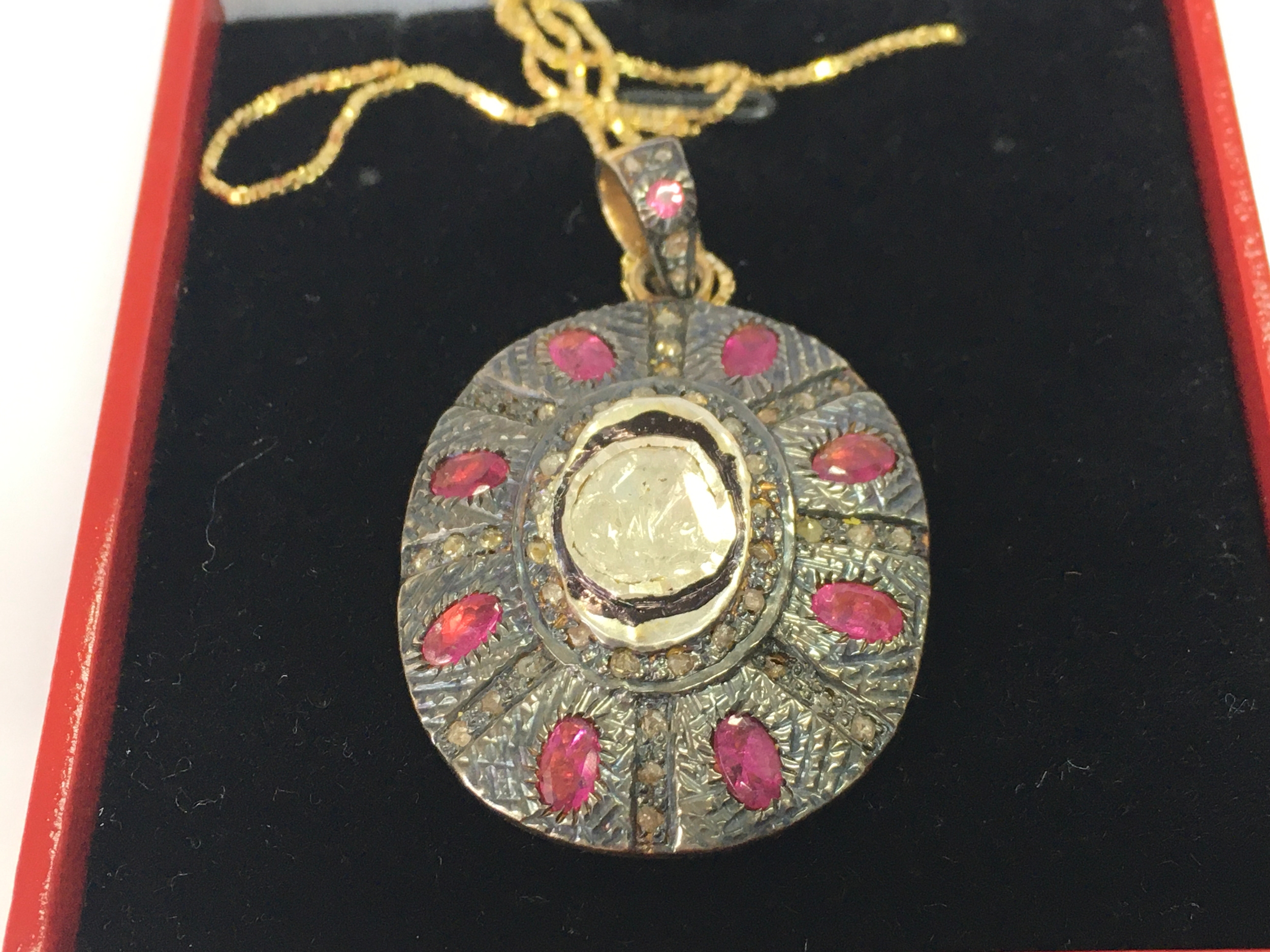 Silver gilt pendant set with central polki diamond, pink tourmaline and rose cut diamonds on a gold plated silver chain.