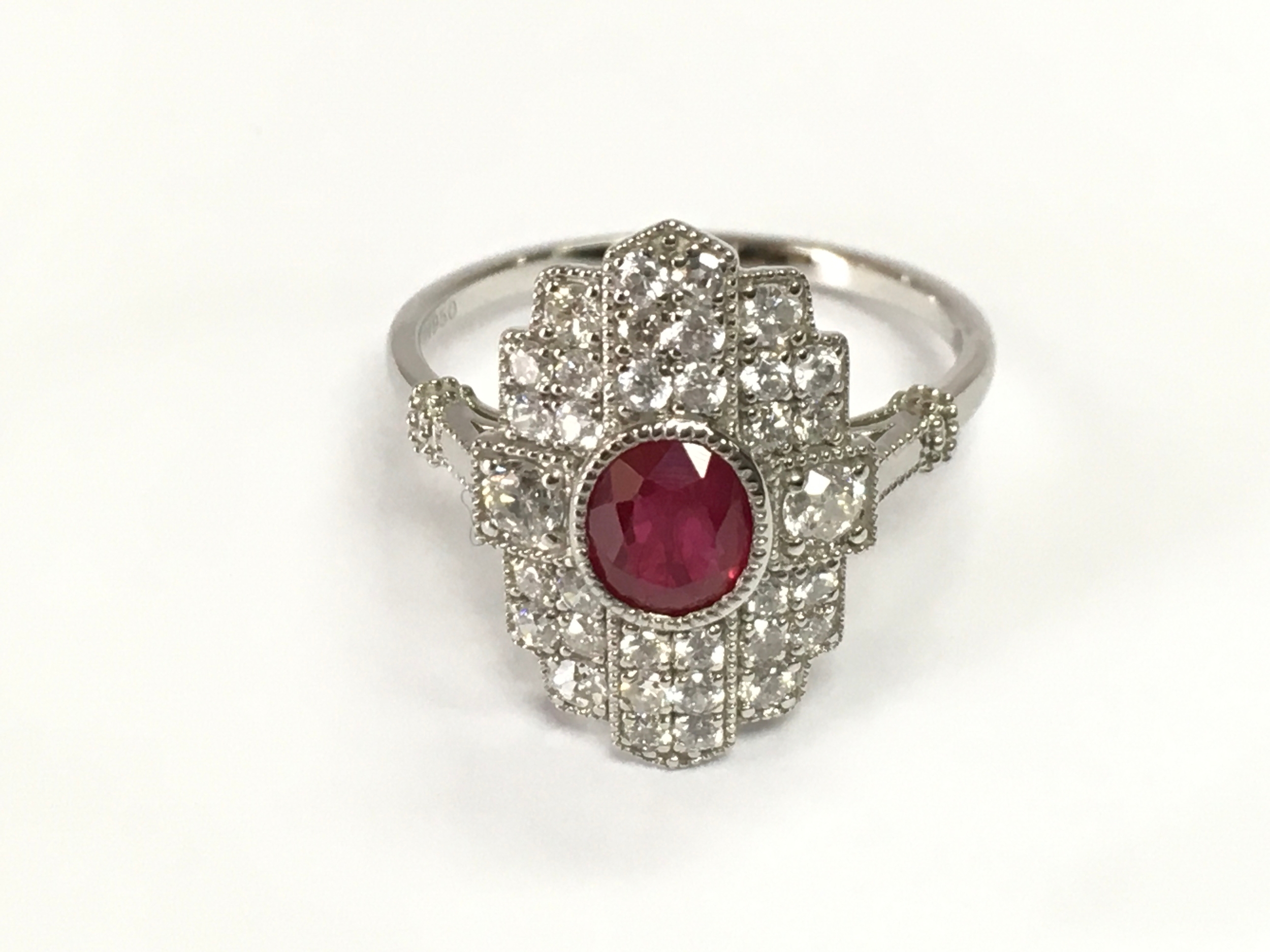 Platinum art deco style ring set with central ruby and surrounded by diamonds. Ruby 0.83ct and diamonds 0.84ct. Size N