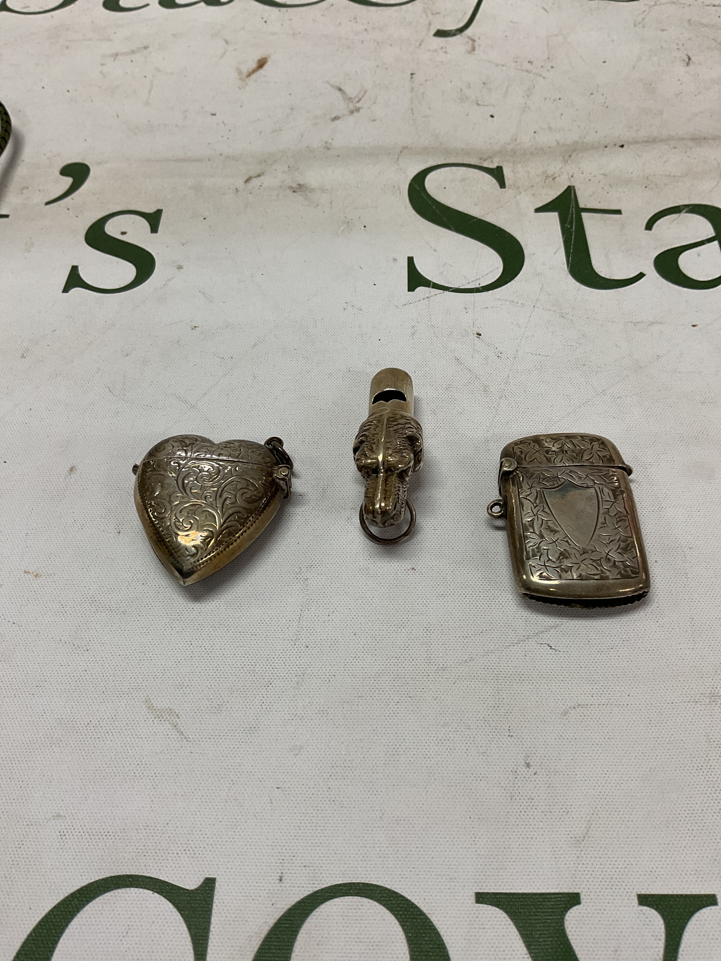 HM silver dogs head whistle stamped 925; along with two Vesta cases one marked 925 the other with full Birmingham marks. Total 47 grams.