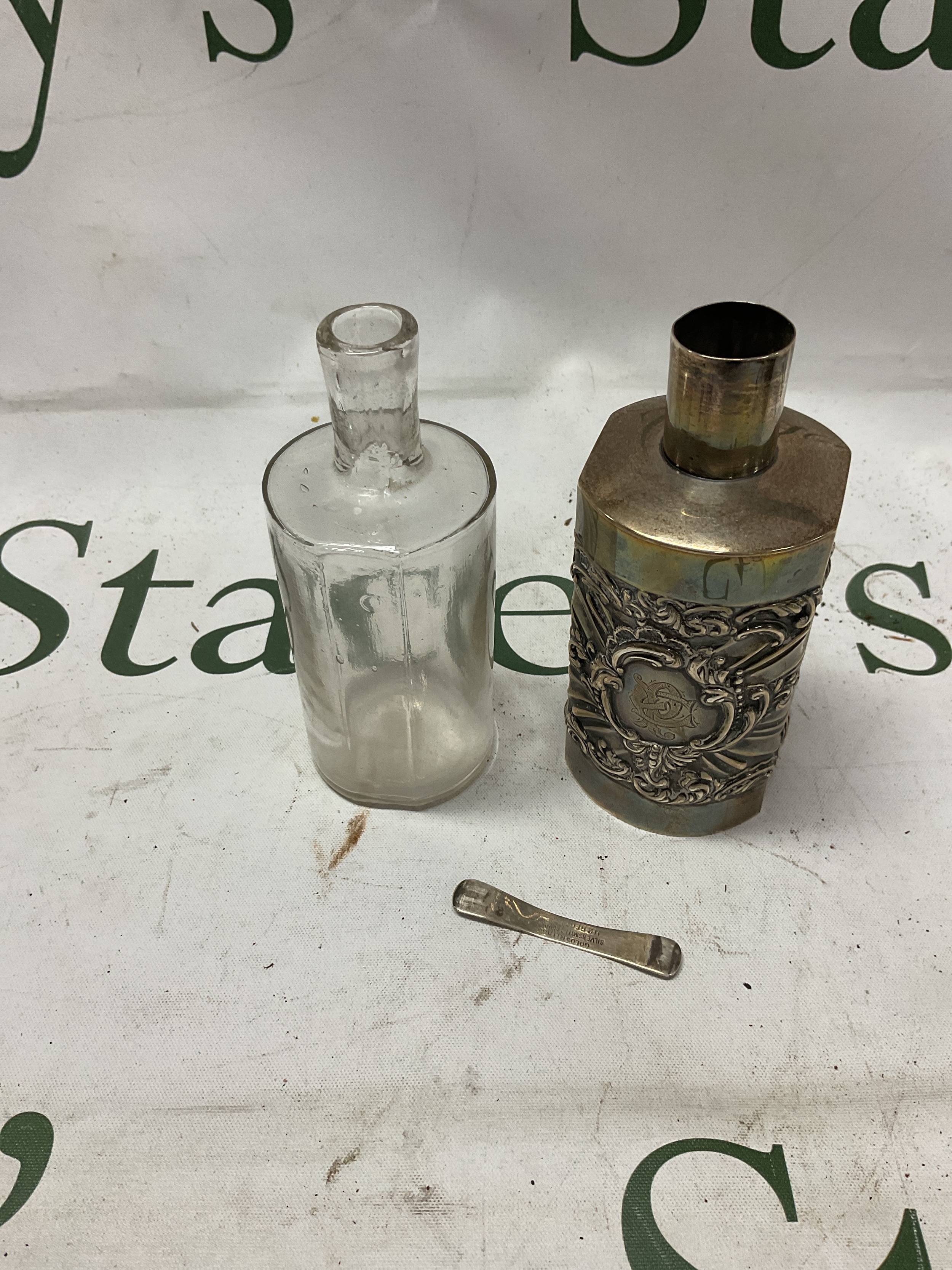 HM silver embossed bottle cover with removable bottle, hm London 1901 by Goldsmith and Silversmith Co. Spring release bar to the base also hallmarked.weight 100grams.