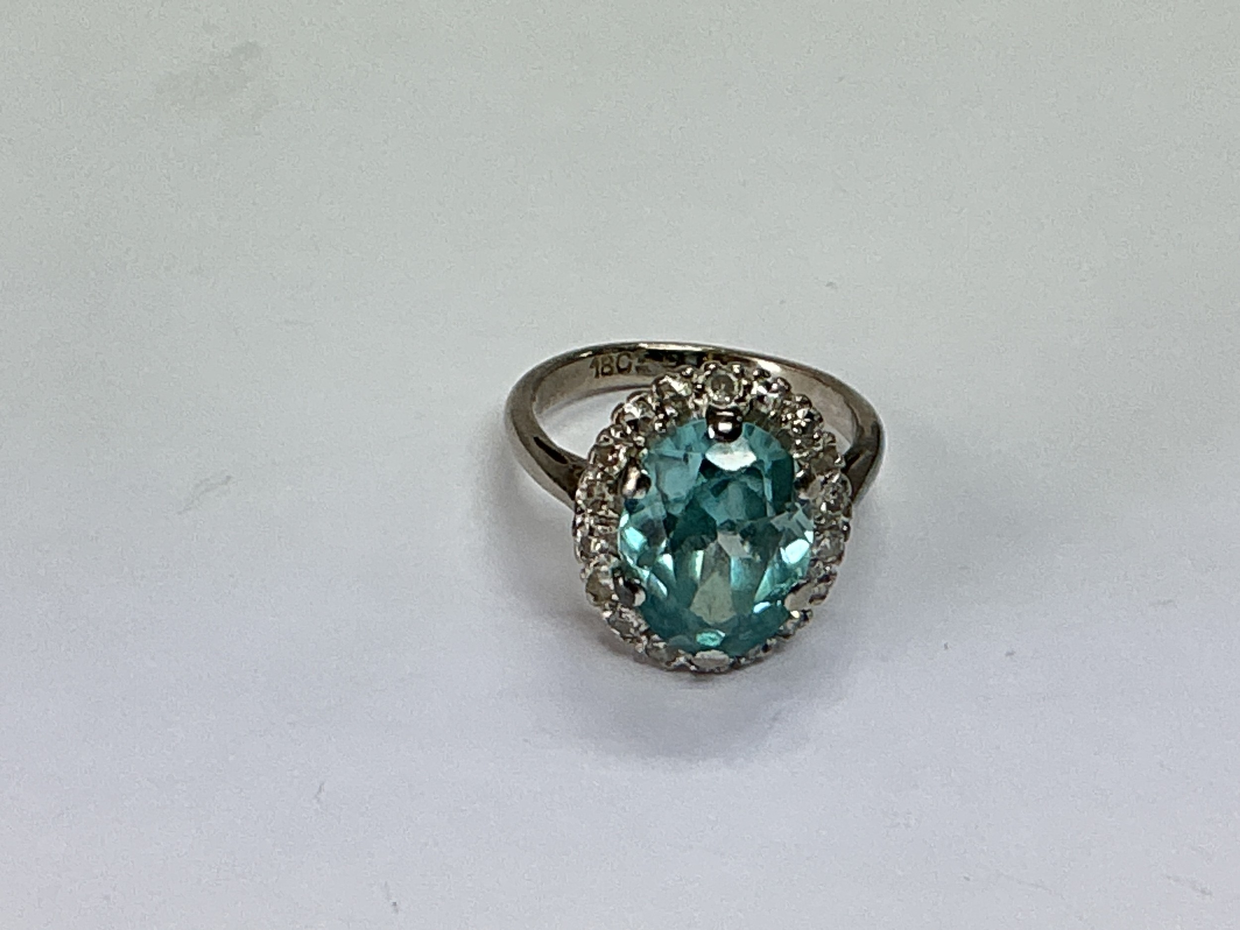 An 18ct white gold ring set with a central blue zircon surrounded by diamonds, approx 5g and approx size I.