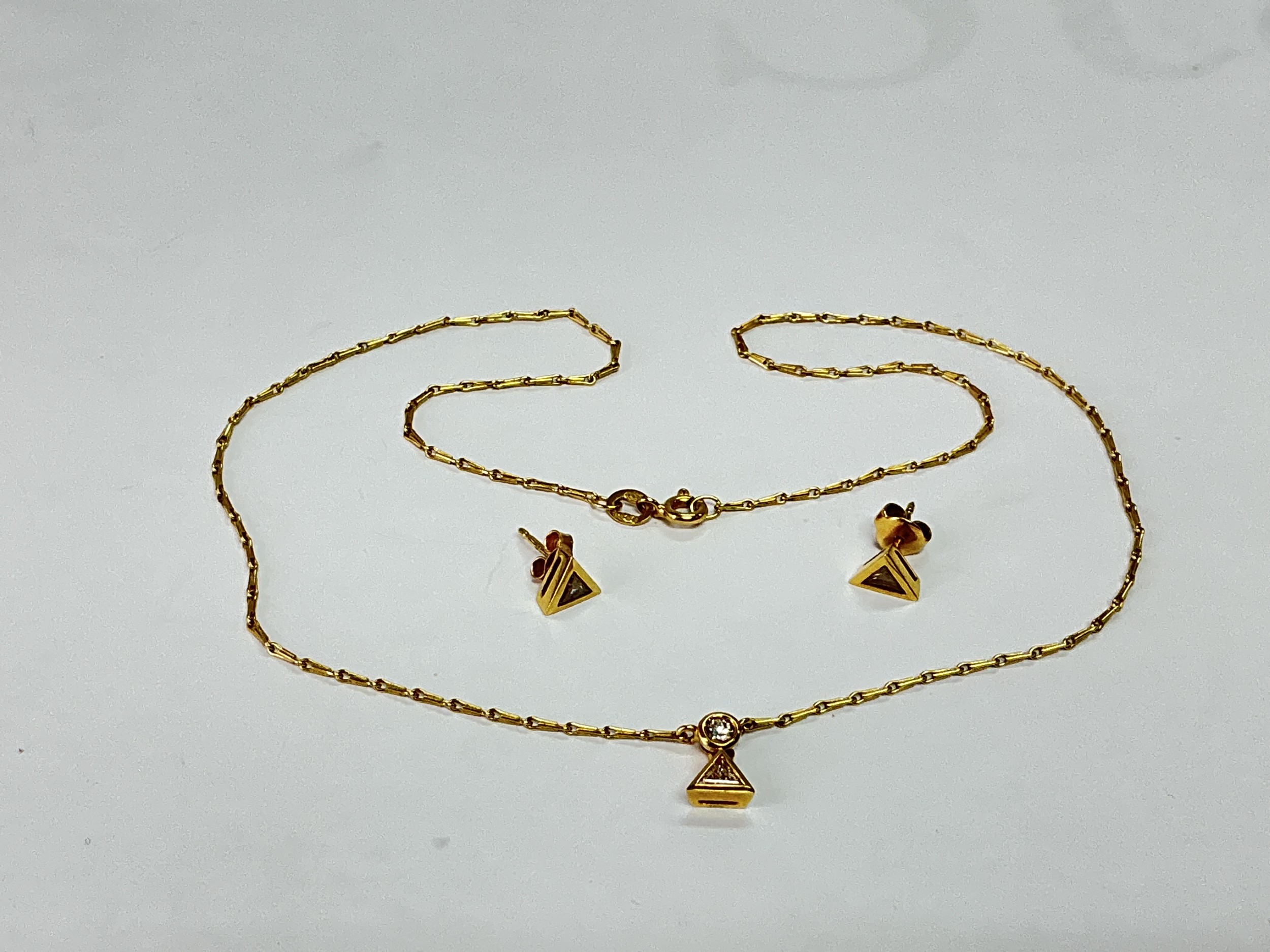 An 18ct gold and diamond pendant on chain with a pair of matching earrings, total weight approx 5g.