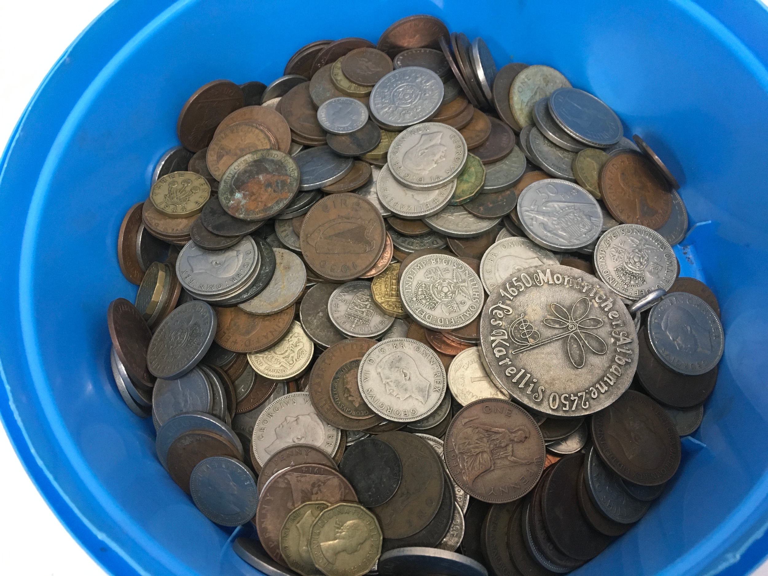 A collection of british coins including pennies, shillings etc also a vintage silver-toned French souvenir medallion from the Les Karellis ski resort area.
