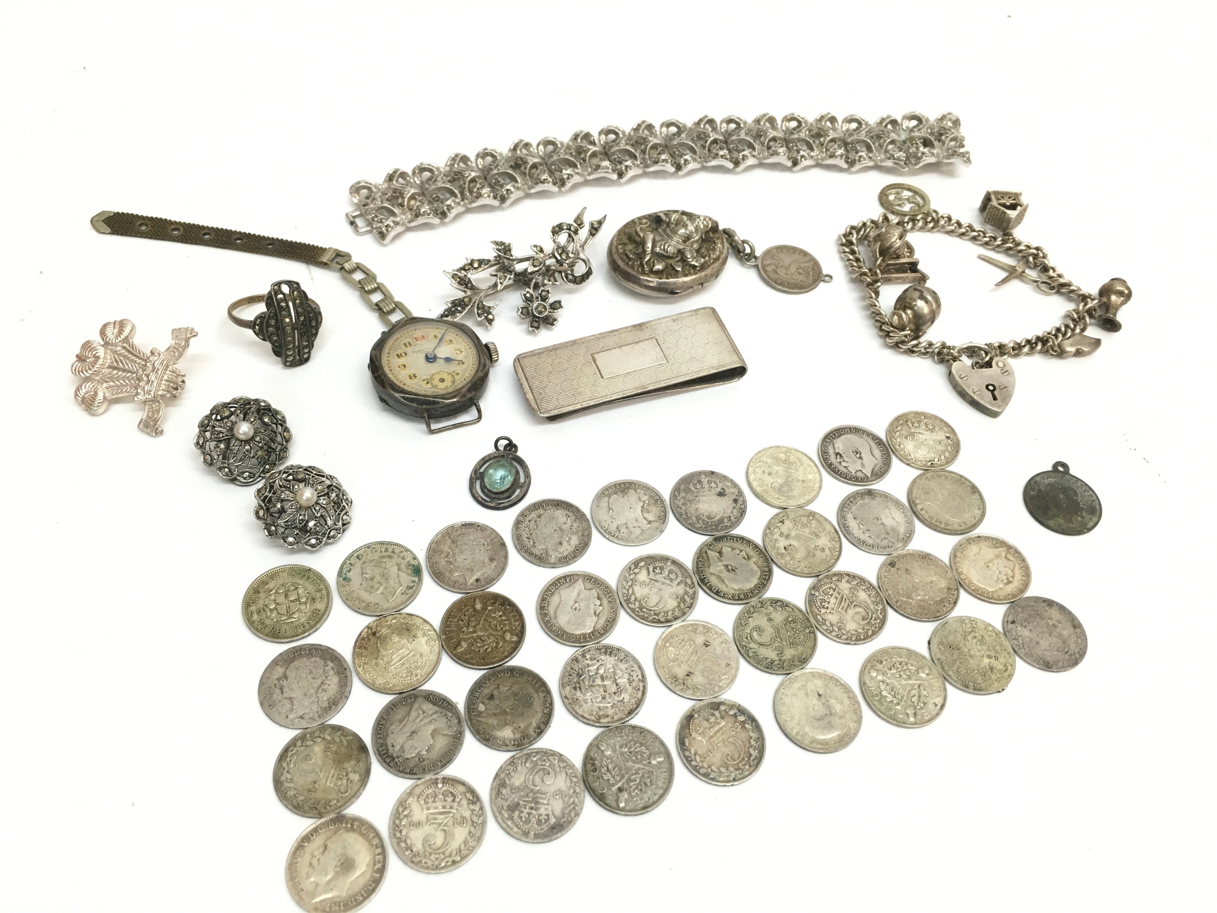 A Collection of silver items including a money clip, watch, bracelet, bangle, charm bracelet, clip on earrings etc. 214g total weight 
