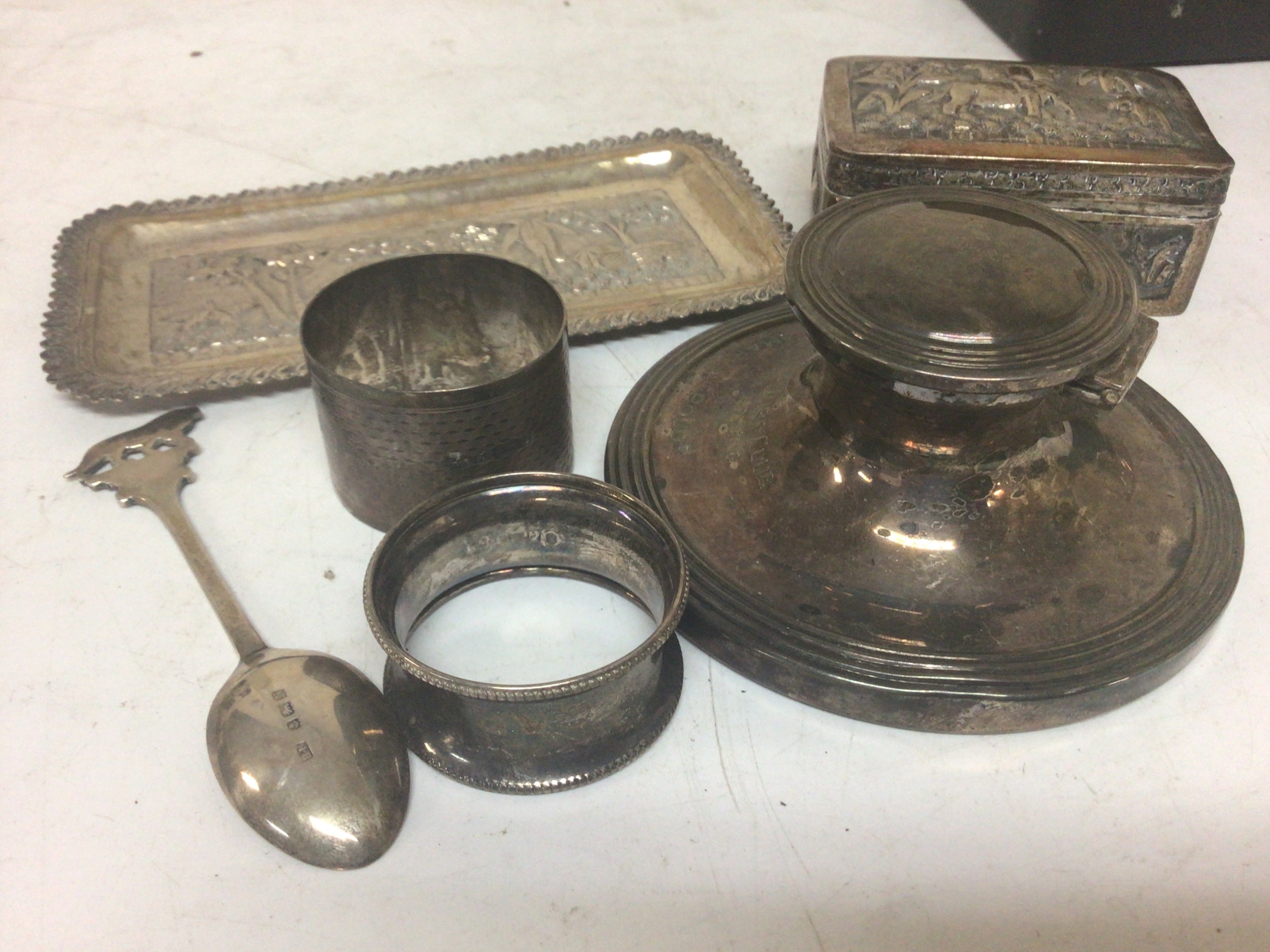  A silver ink well of circular shape napkin rings and Indian white metal trinket box and small rectangular tray. (6) 