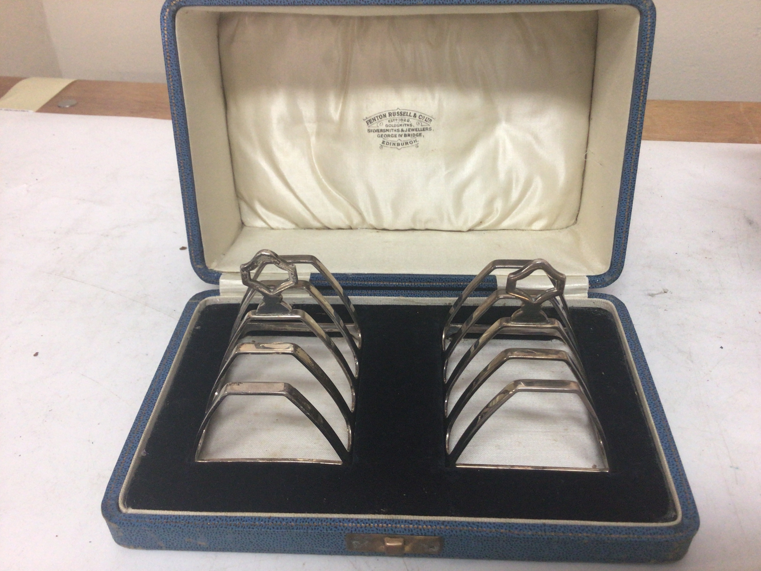   A Pair of silver toast racks with Birmingham hallmarks 1933 in a fitted retailers box Fenton Russell & Co Edinburgh. Total weight 130g 