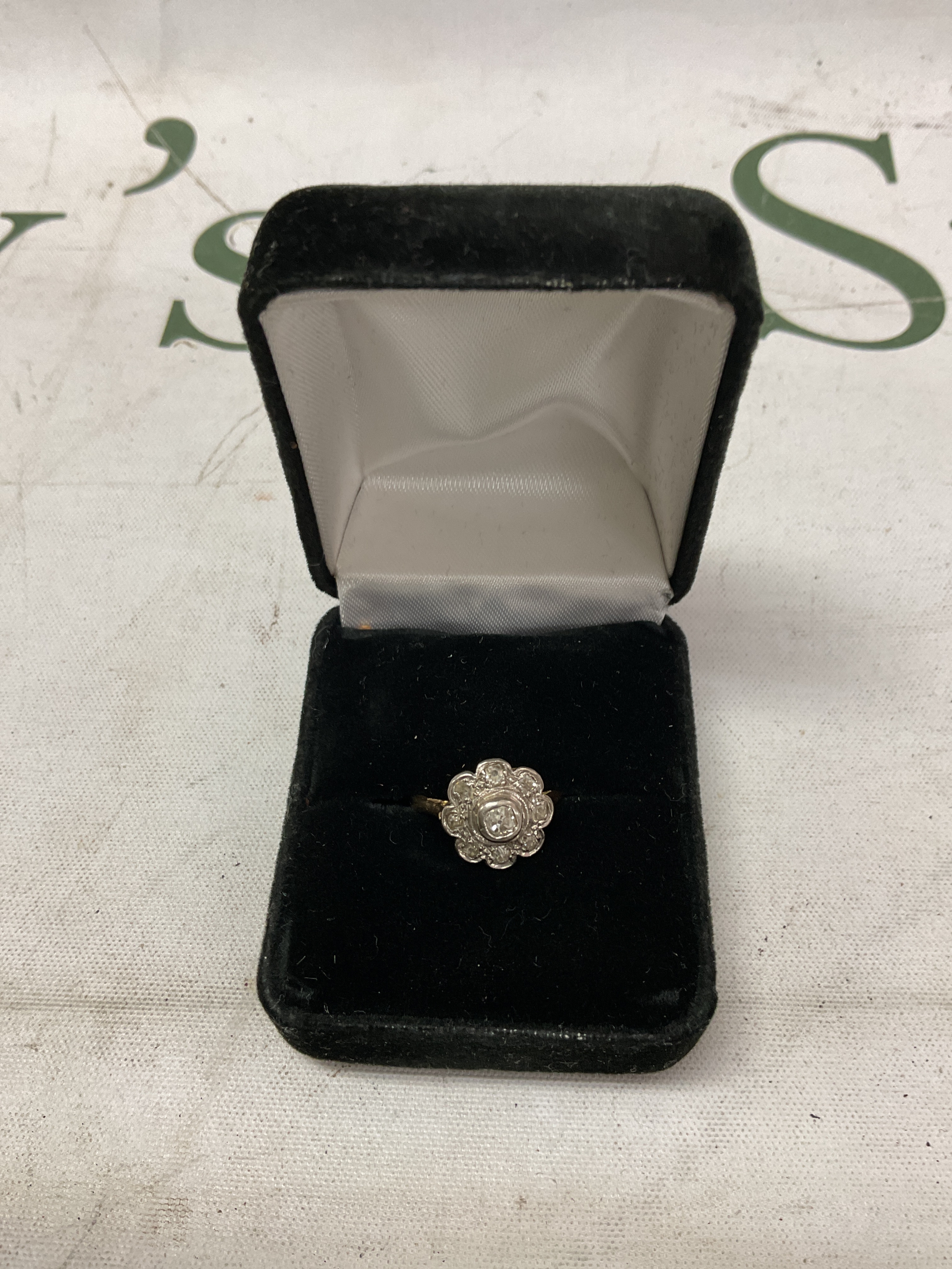 Vintage 18 ct and platinum diamond daisy ring,set with 9 old cut stones and a cushion cut to the centre, 4 grams.