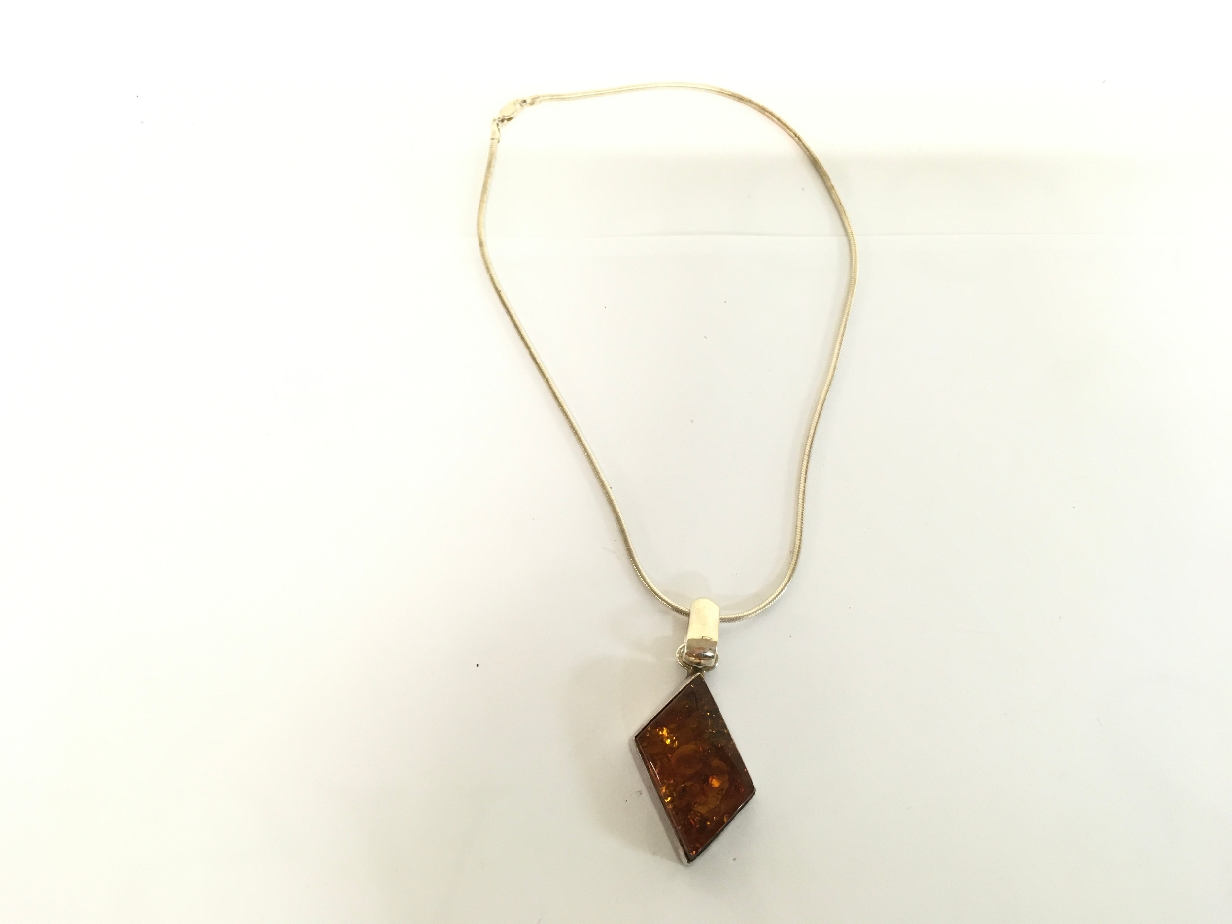 An amber pendant on a silver chain.