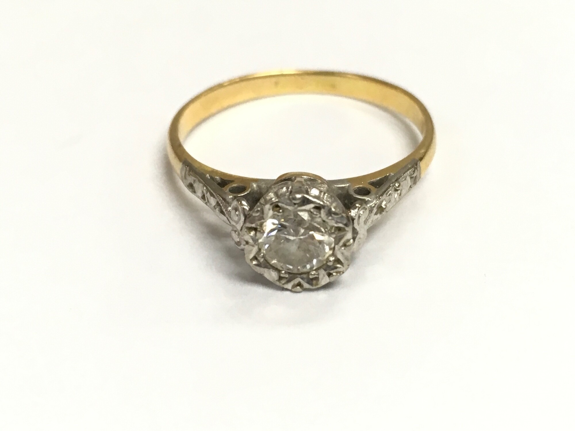 An unmarked gold and platinum solitaire ring. Size L 1/2 and 2.36g