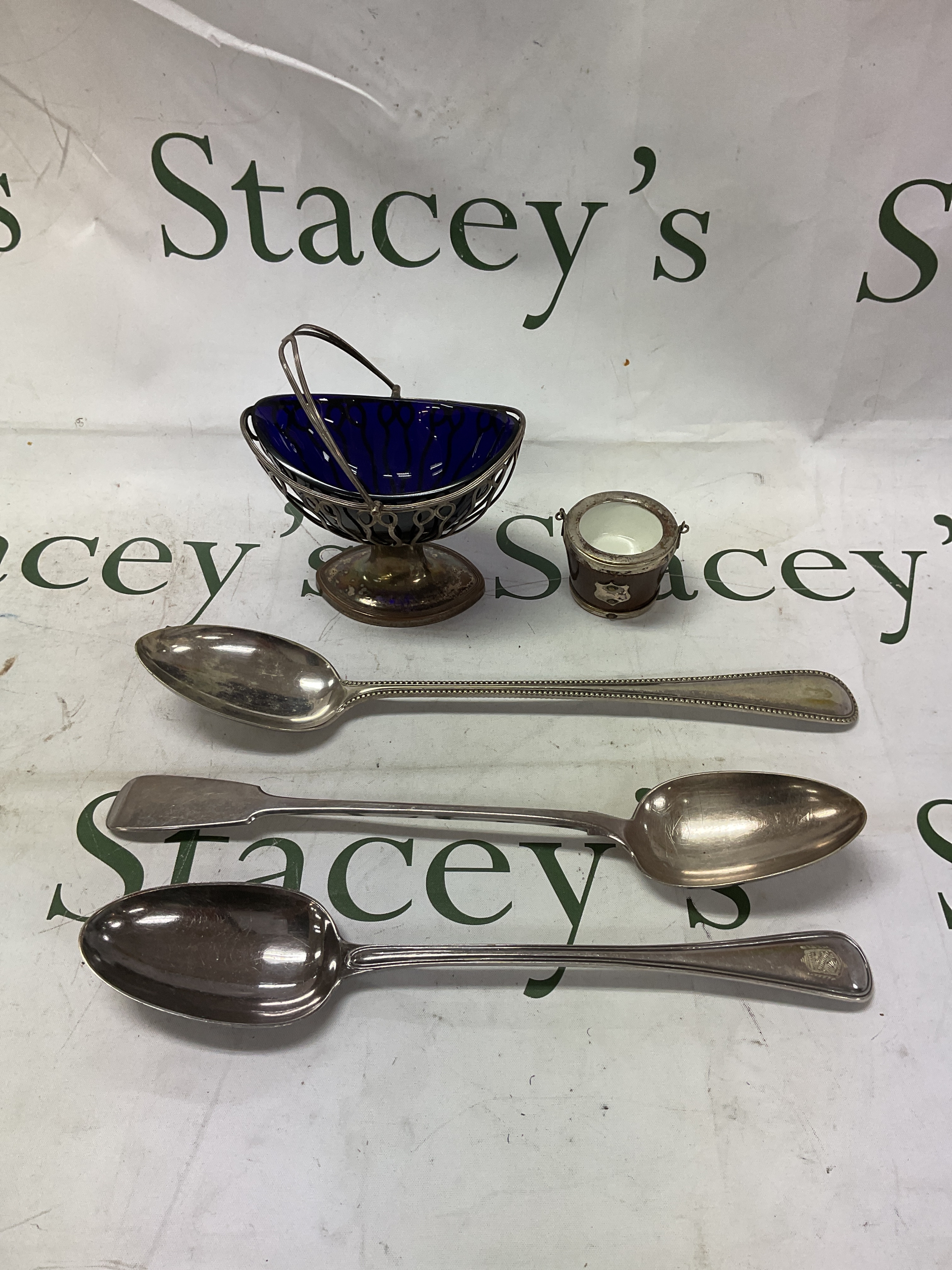 Three large silver plated serving spoons, a navette shaped blue glass lined Bon Bon dish and small silver plated salt.