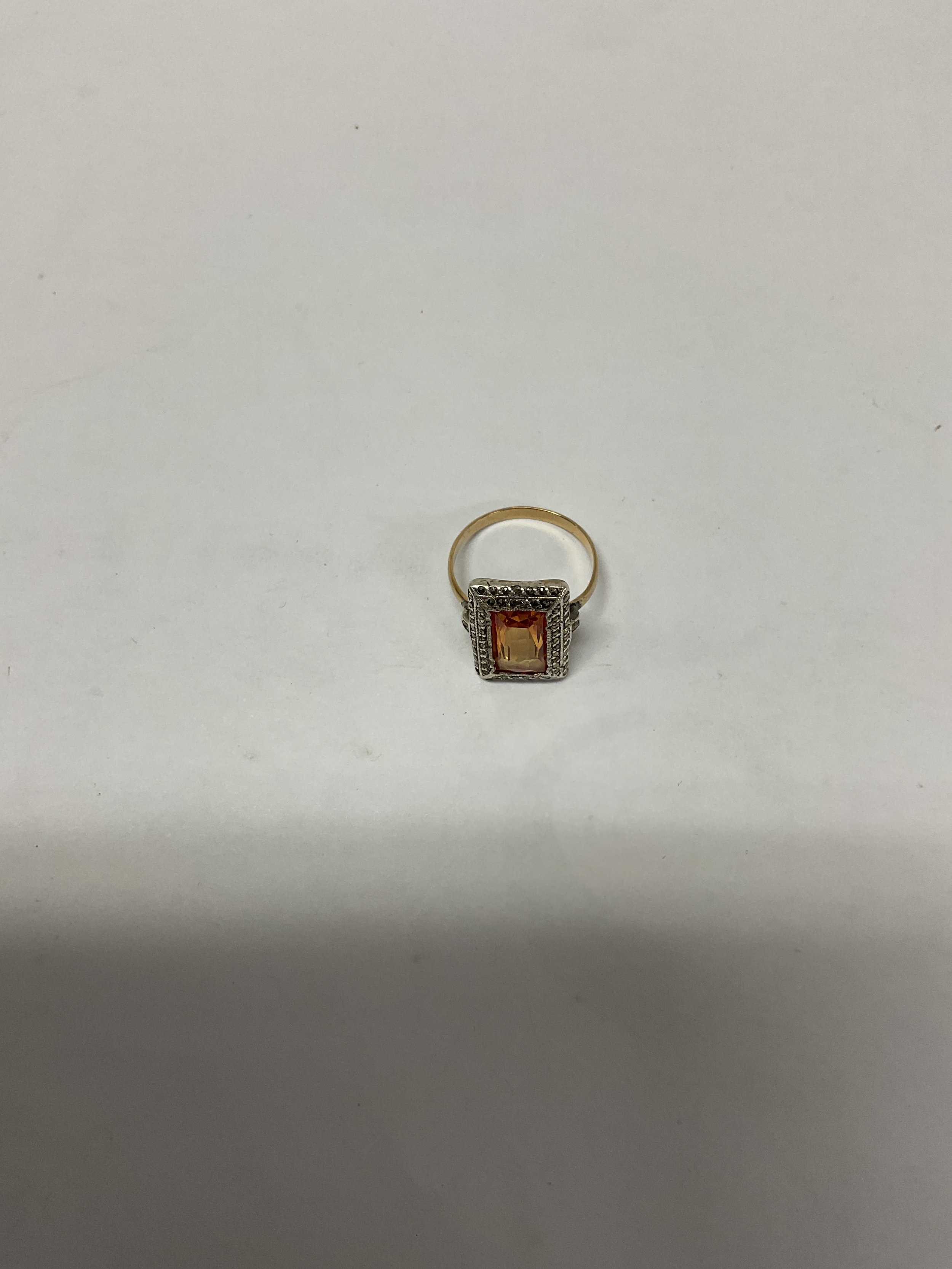 Gold ring set with silver and marcasite square surround to orange set central stone.