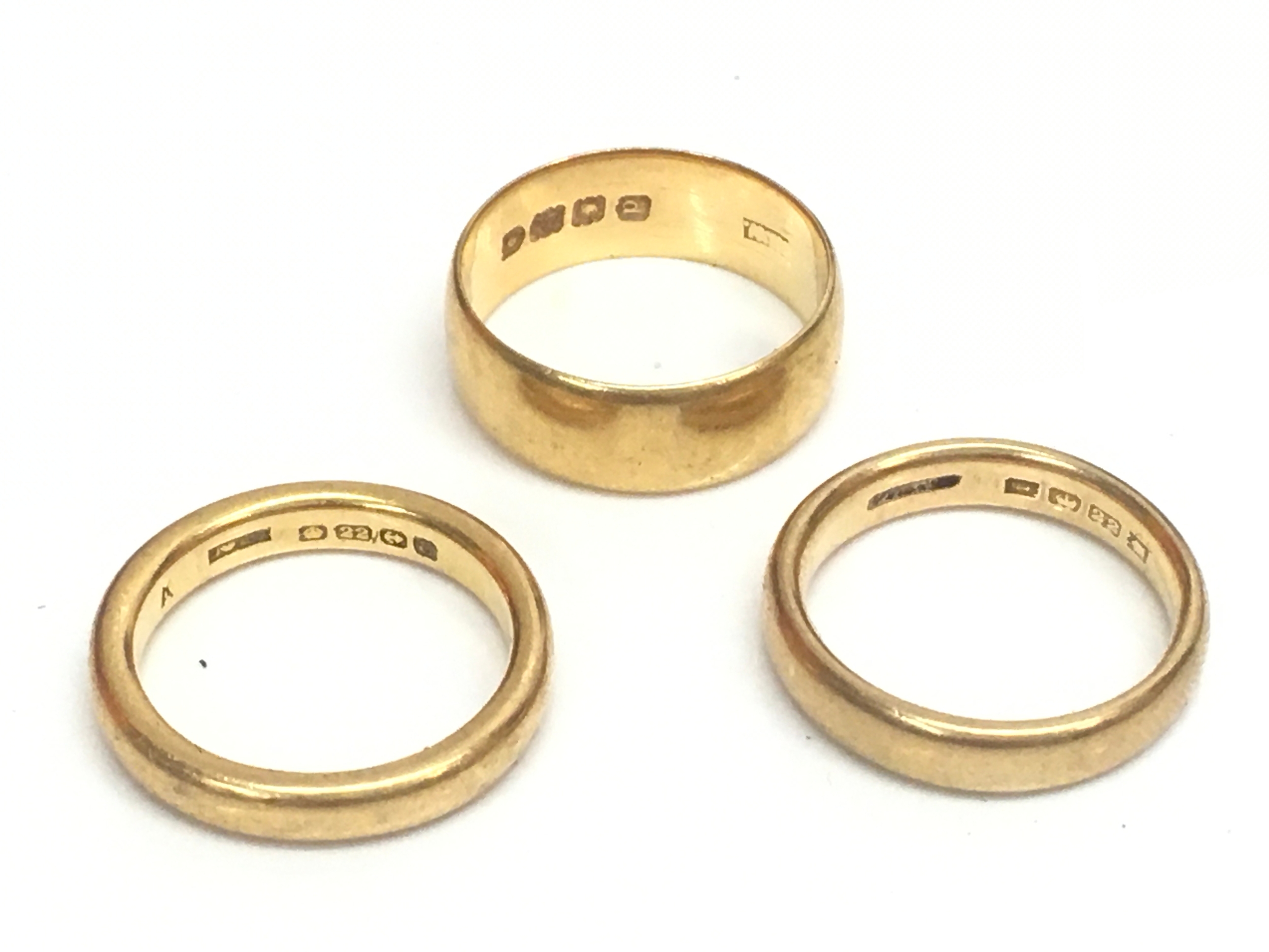 Three 22ct gold wedding bands. Sizes L, K, M. 18.9g