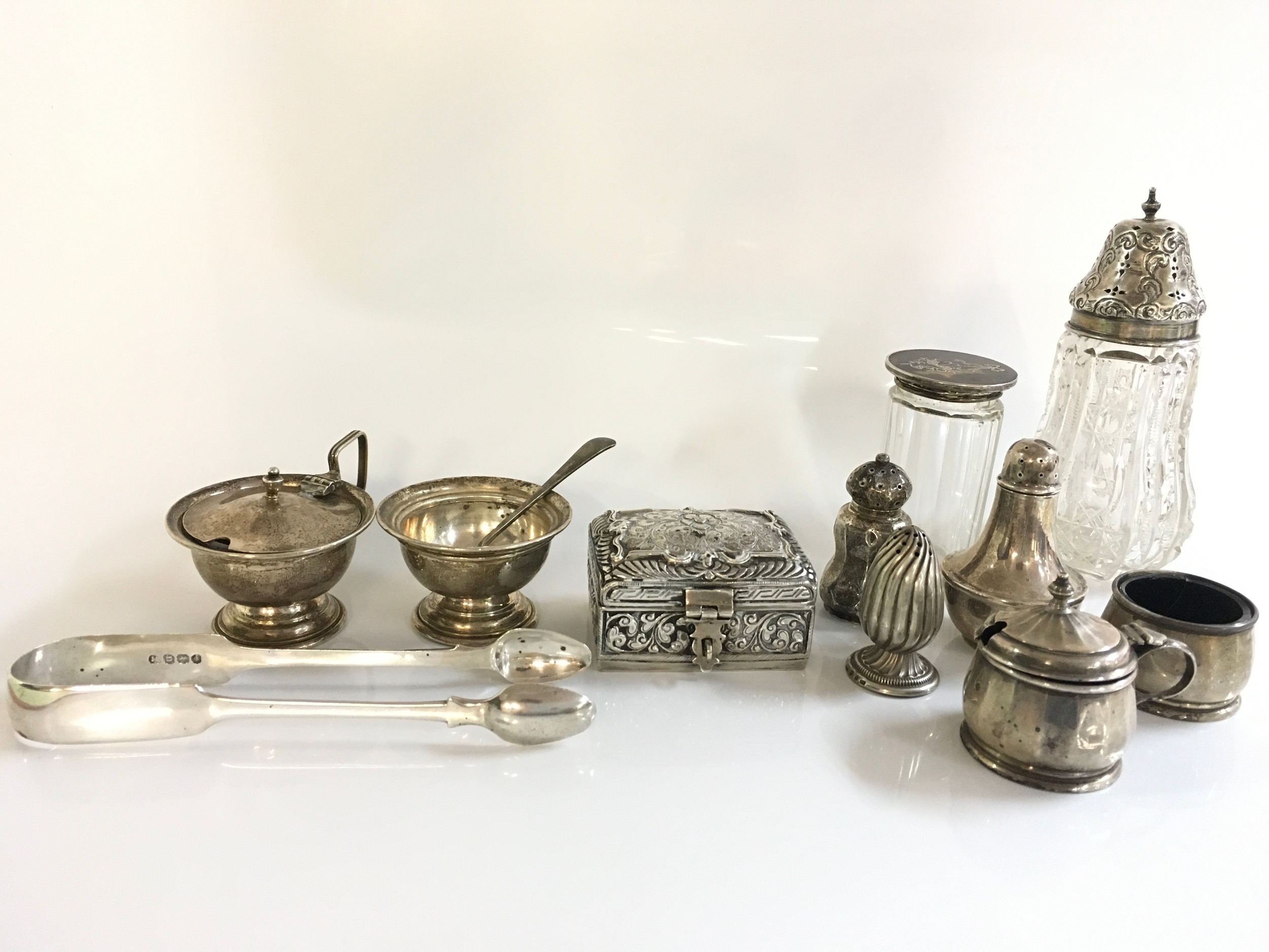 A collection of silver items including condiments, glass shaker and container, small silver ttrinket box, silver tongs . 370 grams total silver weight approximately