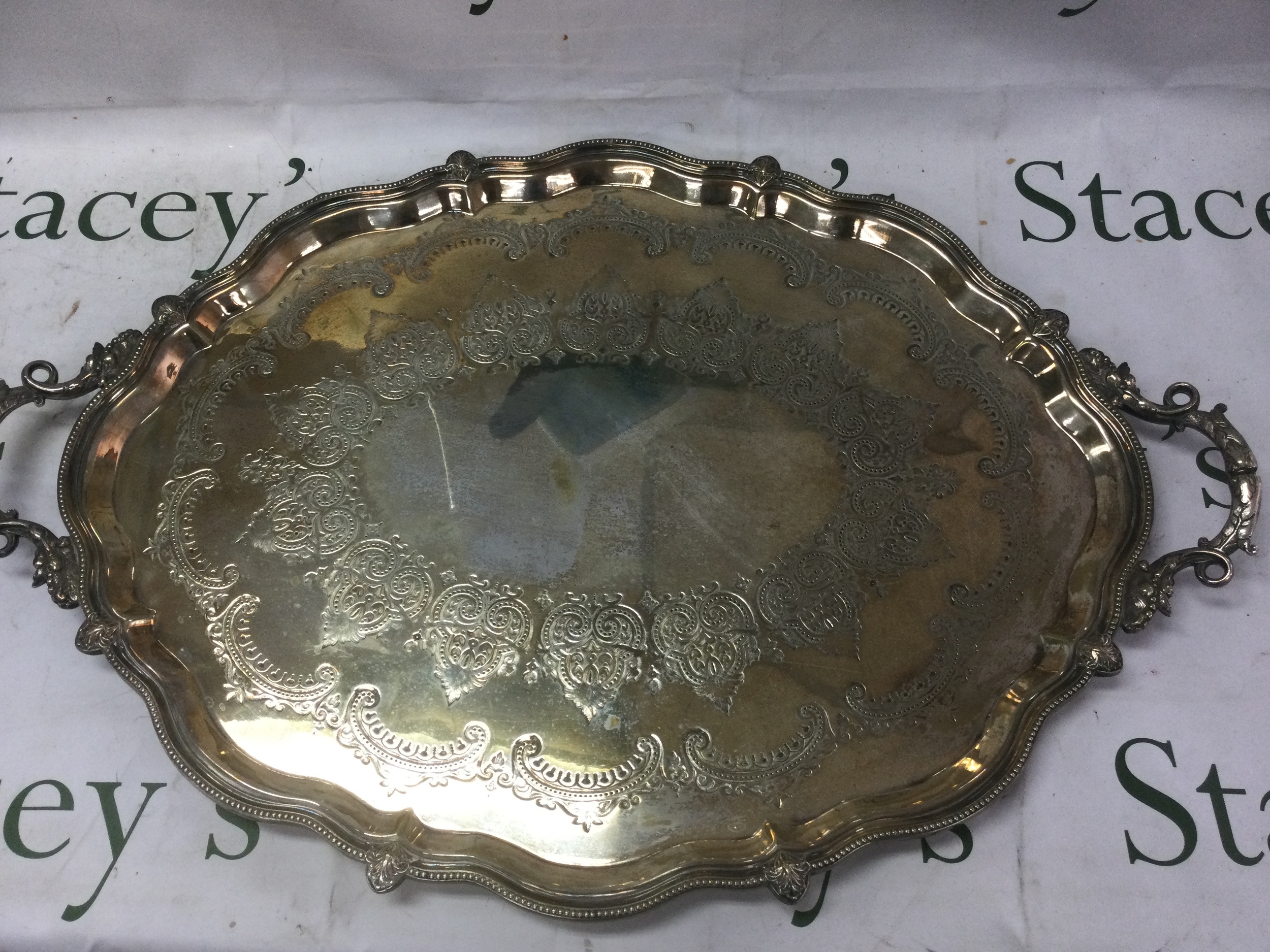A large silver plated tray with warped edges