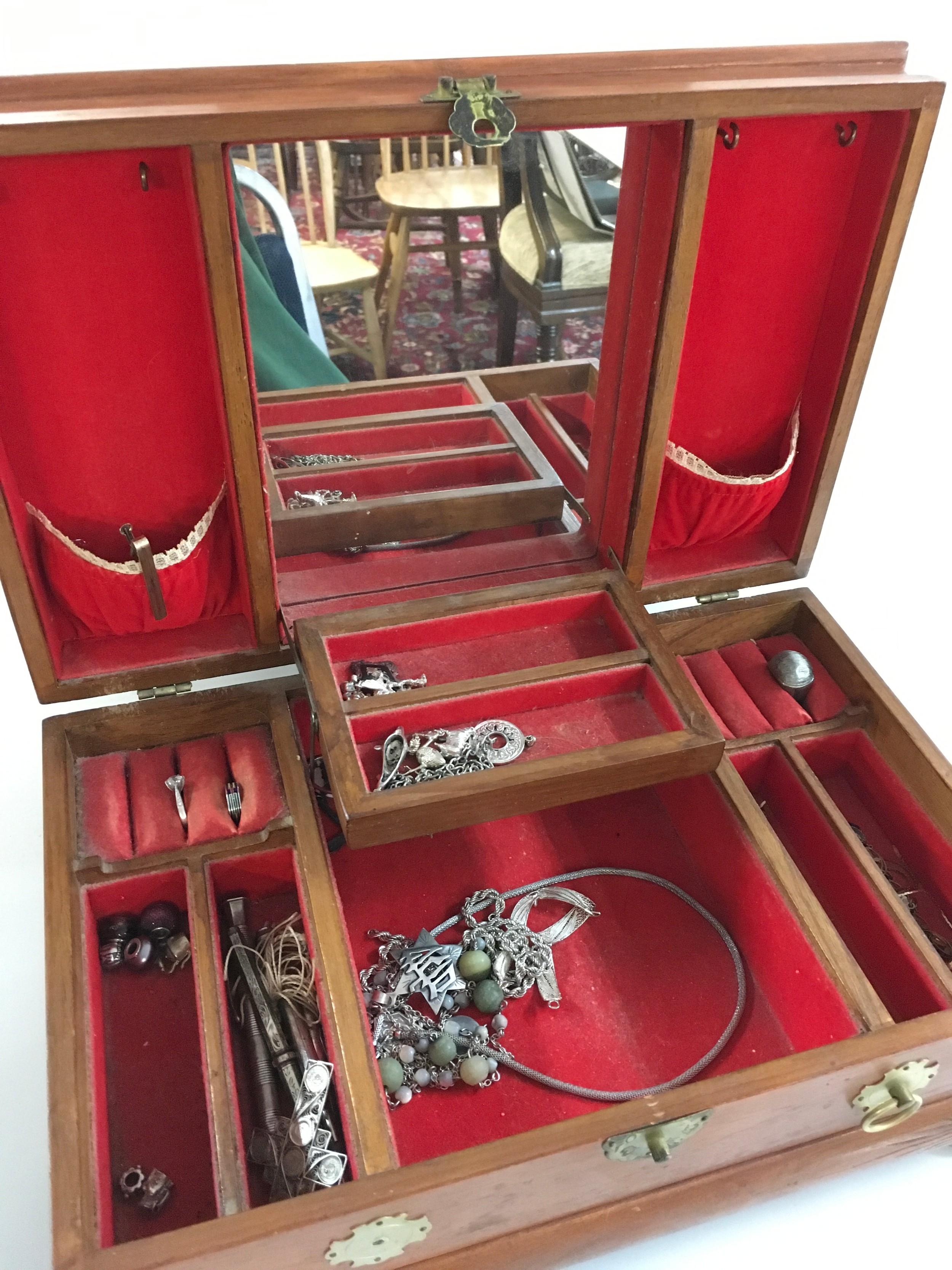 A wooden box with lots of silver jewellery