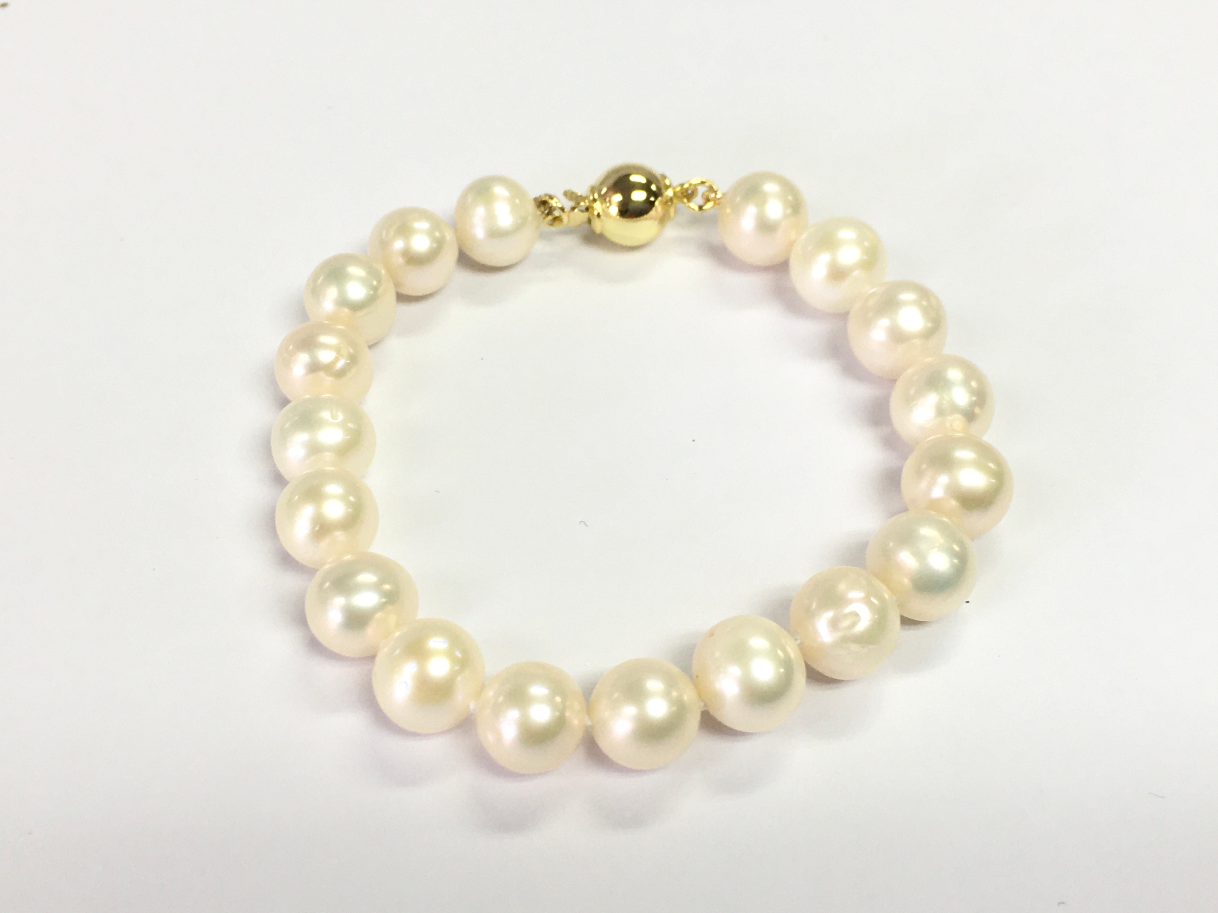 White cultured pearl bracelet with gold plated silver clasp.
