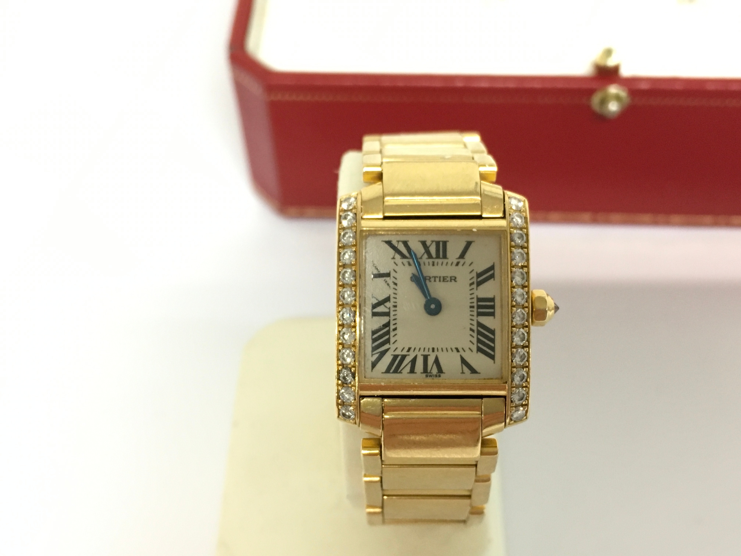 Cartier Tank Française (Reference 2385) luxury ladies' watch. Case and Bracelet 18k yellow gold. Small model measuring approximately 20.0 mm x 25.0 mm, with a thickness of 6.8 mm. Gemstones: Parallel vertical brancards (bezel edges) meticulously set with rows of brilliant-cut diamonds. Cream dial detailed with black Roman numeral hour markers, a signature "chemin-de-fer" minute track, and blued-steel sword hands. Crown finished with a faceted crown accented by a diamond. watch is running.