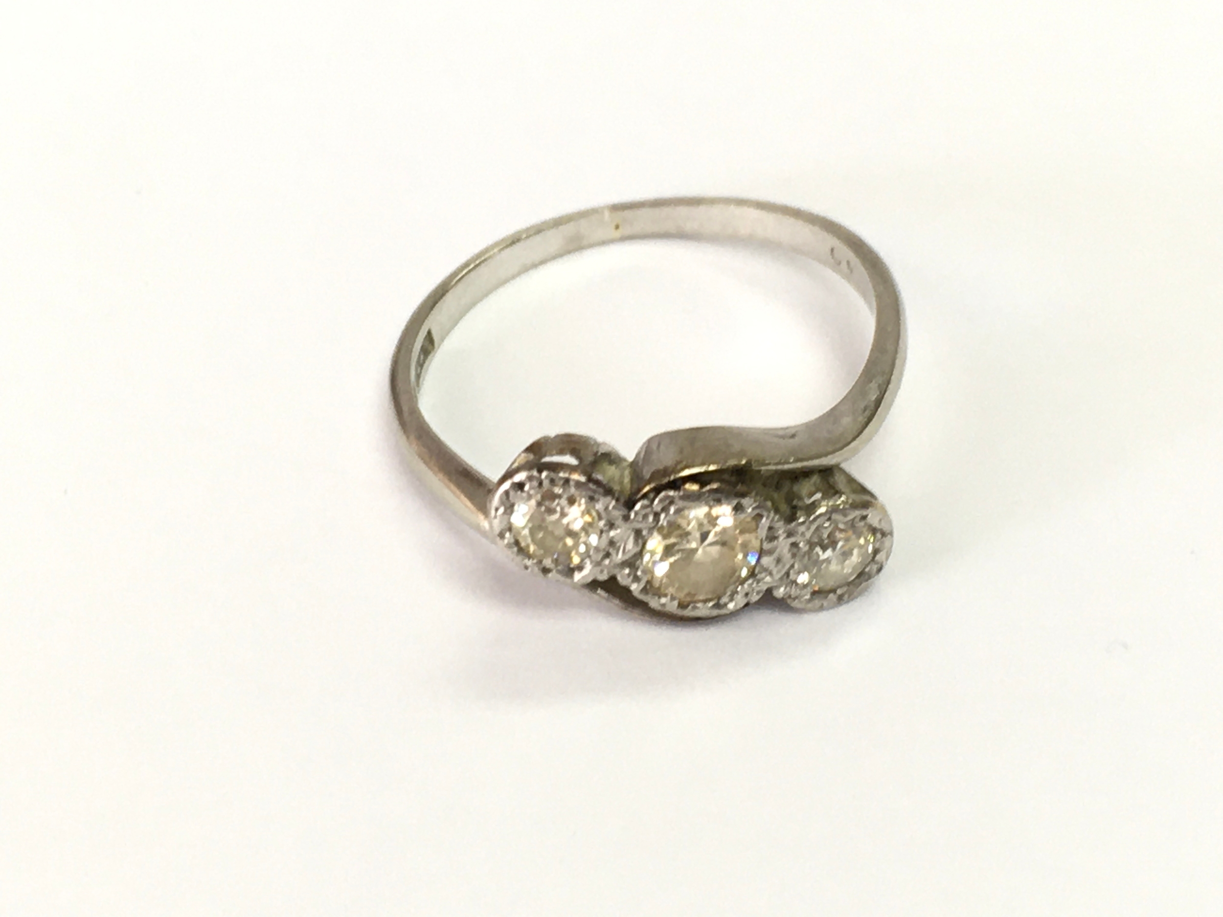 A Platinum three stone diamond ring. Size O 1/2 and 2.7g