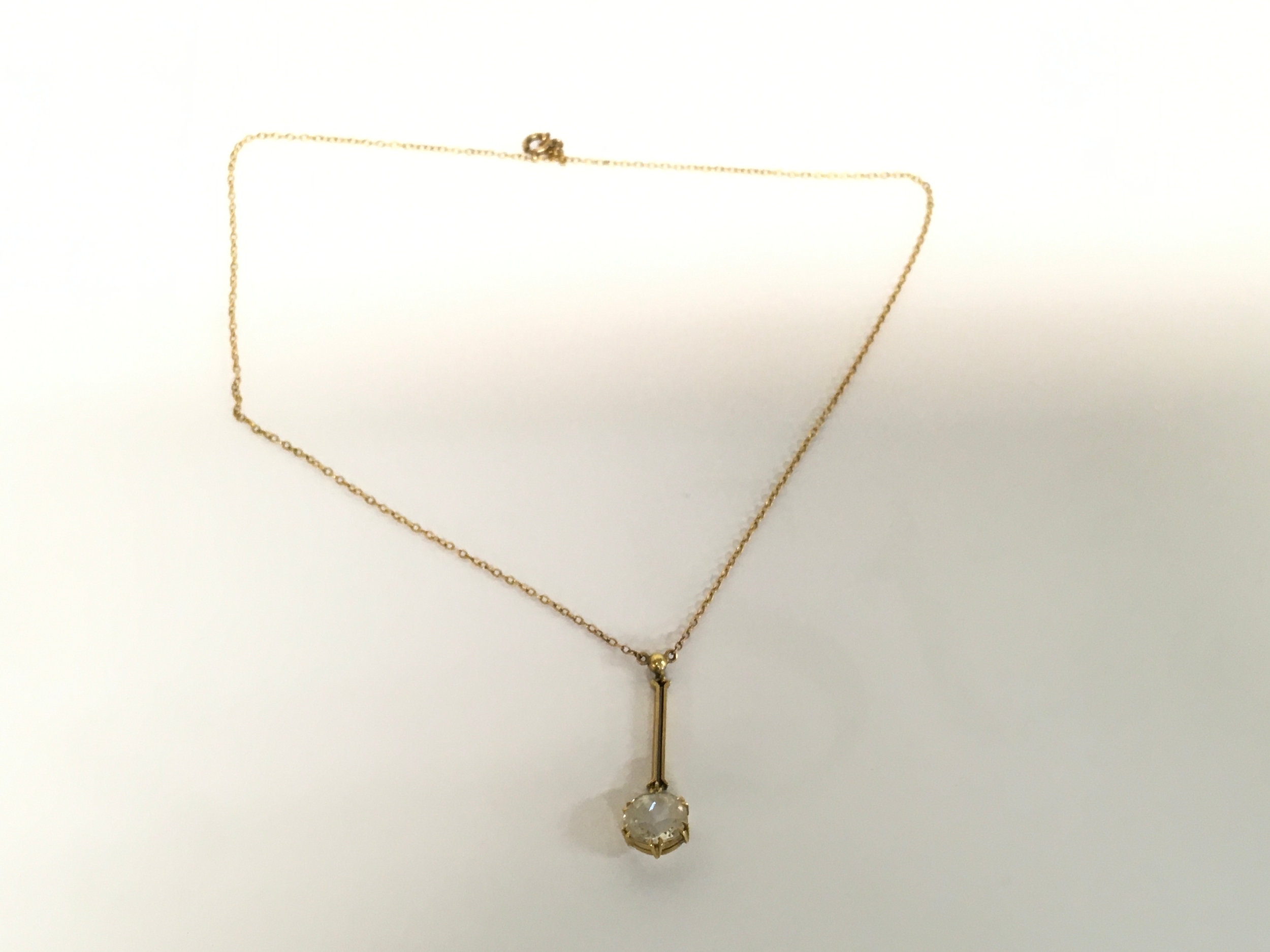 A 15ct gold pendant with white sapphire and gold chain. 