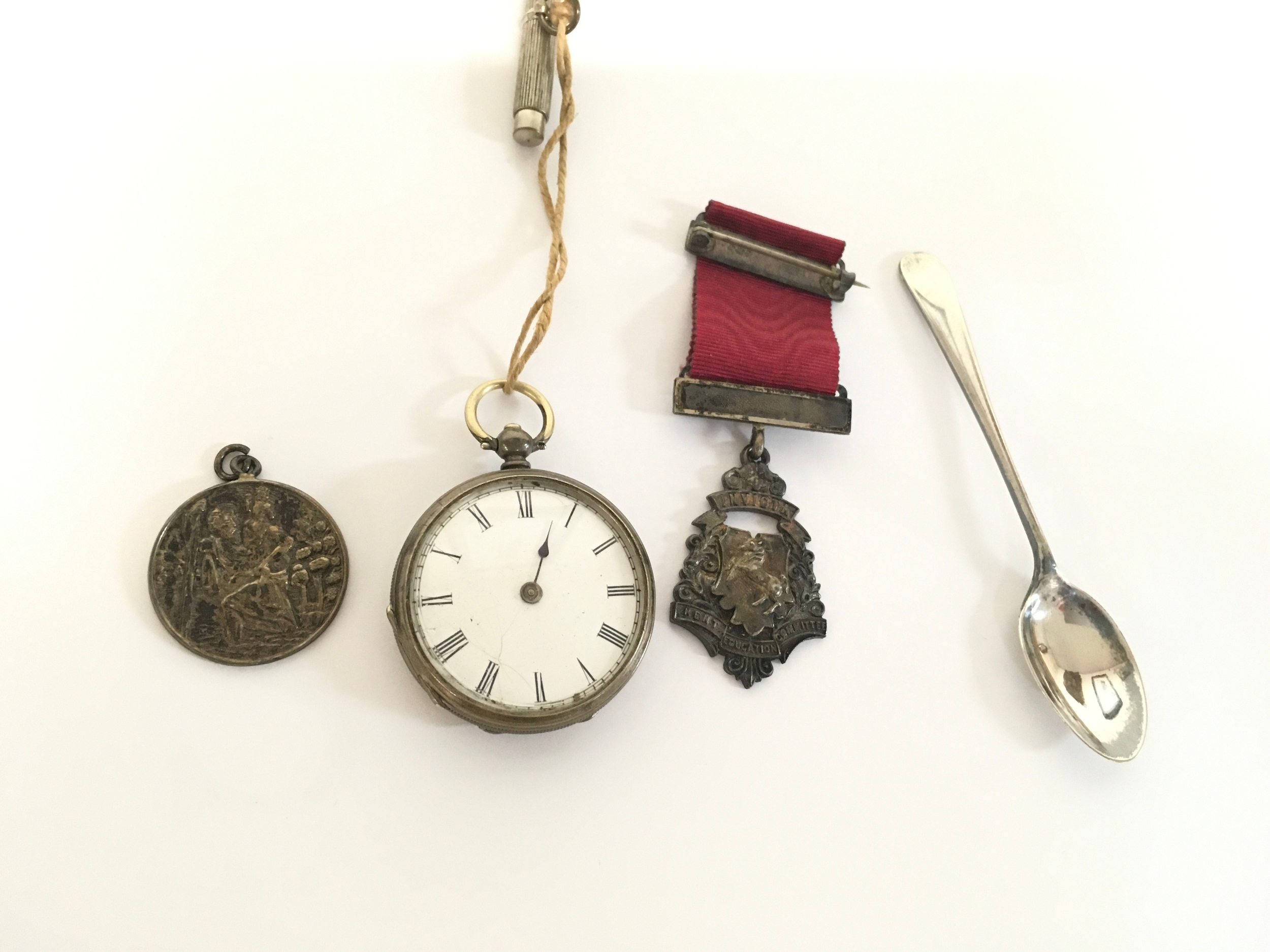 A silver (800) pocket watch along with silver medals and a silver spoon. 75.9g total.