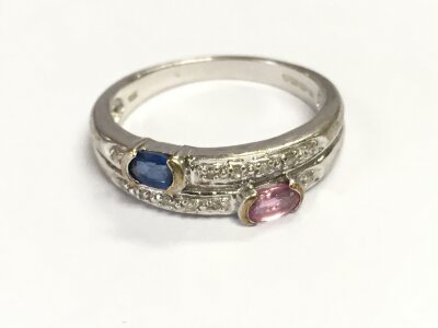A 14ct white gold ring set with a blue sapphire and pink tourmaline also chip diamonds. Size Q and 4.16g