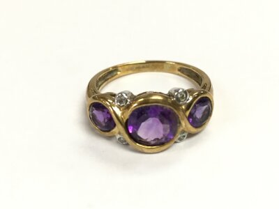 A 9ct gold ring set with amethyst and small diamonds. Size N 1/2 and 2.90g