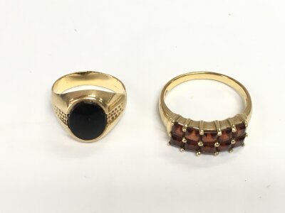 A small 9ct signet ring and a 9ct ring set with ruby coloured stones. Sizes F and P and 5.16g total.