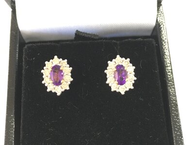 Pair of 9ct gold oval amethyst and diamond cluster stud earrings. Approximately 0.48ct amethyst and 0.52ct diamonds