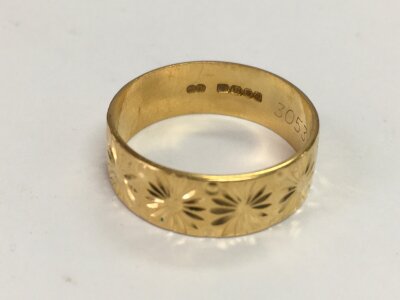 An 18c gold wedding band. Size T 1/2 and 6g