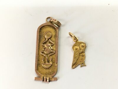 A gold cartouche and an owl charm.
4.05g
