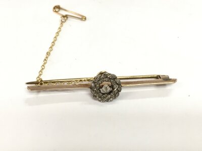 A gold bar brooch set with diamonds. 3.80g