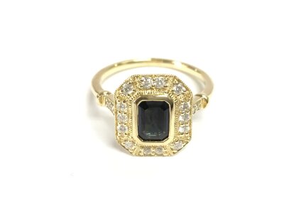 A 9ct gold octagonal dress ring set with a step cut sapphire and diamonds surrounds and shoulders. Size N