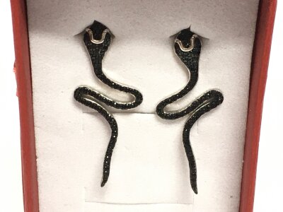 A pair of silver snake earrings with black spinels