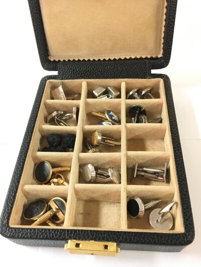 A Box Containing A Collection Of Cufflinks.